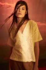Blusa de borderie blanca con escote en V y mangas cortas, con diseño de perforaciones.
