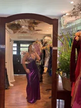 Vestido largo negro con escote en V, cut outs laterales bajo el busto y breteles finos cruzados y atados en la espalda.