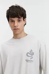 Remera oversize color crudo con efecto acid wash y estampado en la espalda con diseño de serpiente en círculo con texto.