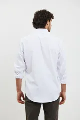 Camisa blanca de corte sport, con cuello clásico y un bolsillo en el pecho.