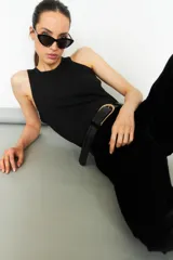 Pantalón de pana negro, corte slim, con cintura alta y cierre frontal con botón y cremallera.