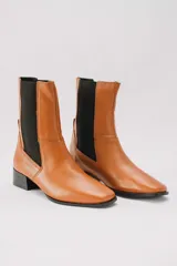 Botas de cuero rojas con elástico negro en los laterales, punta cuadrada y taco bajo.