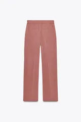 Pantalón de vestir color beige, de tiro alto, con cintura elástica en la parte trasera, bolsillos delanteros y falsos bolsillos de vivo en la parte trasera.
