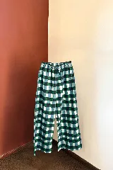 Pantalón de algodón con estampado a cuadros en tonos verde, azul y blanco. Tiene elástico y cordón ajustable en la cintura.