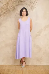 Vestido midi lila de lino, corte amplio, sin mangas y con bolsillos laterales con volados.