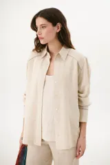 Sobrecamisa azul de lino con cuello camisero, manga larga y cierre frontal con botones.