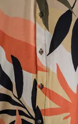 Camisa de manga larga con estampado de hojas en tonos beige, naranja, negro y verde.