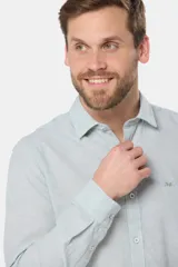 Camisa de manga larga, color celeste con finas rayas blancas, confeccionada en una mezcla de lino y algodón. Presenta un corte slim fit y no tiene bolsillo.