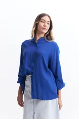 Camisa azul de manga larga con cuello mao y corte holgado.