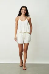 Short negro de tiro alto con cordón ajustable en la cintura y bolsillos laterales. Presenta un corte holgado y ruedos redondeados.