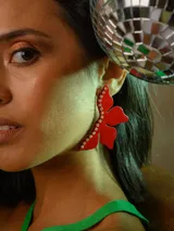 Aros colgantes con forma de flor roja con glitter, detalle de strass y gancho de acero quirúrgico.