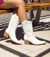 Bota texana de cuero color marrón, con caña media, punta fina y taco de madera.