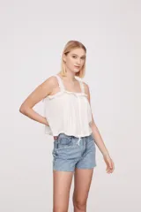 Musculosa color salmón con breteles finos y detalle de puntilla en el escote.