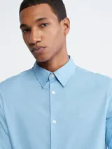 Camisa celeste de vestir Calvin Klein, de corte entallado, manga larga y cuello clásico.