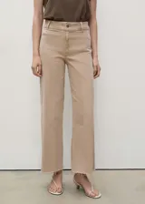 Pantalón de jean color beige, de corte culotte, tiro alto y bajo deshilachado.