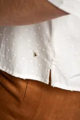 Blusa blanca de viscosa con escote en V, mangas 3/4 abullonadas y detalle de plumeti.