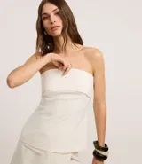 Blusa strapless de sastrería con escote recto doblado y rayas verticales estilo tiza. Cierre trasero con cremallera.