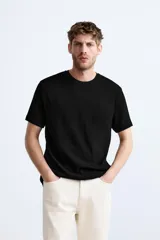 Jersey de punto color marrón oscuro, de corte relajado (relaxed fit), con cuello redondo y manga corta.