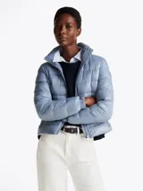 Campera celeste acolchada con relleno de plumón, cuello chimenea y capucha plegable. Cuenta con cierre de cremallera, bolsillos laterales con cremallera y puños elásticos con botones a presión.