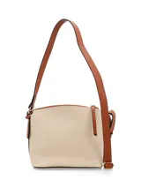 Bandolera color peltre con correa de cuero marrón regulable. Tiene un bolsillo externo con cierre y chapita metálica con el logo de la marca.