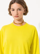Sweater tejido suave y flojo, color crudo, con cuello redondo y mangas largas.