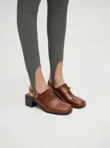 Mocasines color beige con taco bloque de madera color negro y correa trasera ajustable.