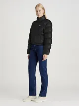 Campera puffer cropped negra de poliéster reciclado con cuello alto, cierre de cremallera, bolsillos laterales, puños elásticos, bajo ajustable con cordón y logo de Calvin Klein estampado en el pecho.