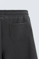 Bermuda negra de corte relaxed fit, con cintura elástica ajustable con cordón, bolsillos frontales y bolsillo trasero de parche.