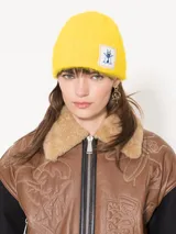 Gorro de lana amarillo con parche bordado de mosca en el frente.