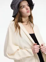 Saco color beige de algodón, con bolsillos laterales y mangas amplias.