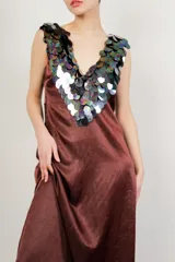 Vestido largo de seda color bordó, con escote en V y apliques de lentejuelas iridiscentes en el cuello y los hombros.