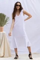 Vestido blanco de muselina 100% algodón, corte recto y largo midi, con cuello en V y sin mangas.
