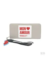 Billetera gris con parche blanco con texto en rojo "Mon Amour" y detalle de labios rojos y azules colgando.