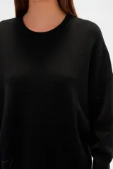 Sweater color crema, de corte holgado, con cuello redondo y mostacillas decorativas.