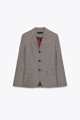 Blazer de cuello solapa y manga larga con estampado de cuadros en tonos marrón y blanco. Tiene bolsillos con solapa en el delantero, abertura en la espalda y cierre frontal con botones.