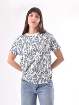 Remera celeste con estampado de hojas blancas.
