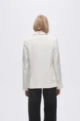 Blazer color crudo de rayon, entallado, con cuello solapa y cierre con un botón.