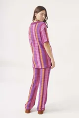 Sweater de tejido crochet a rayas verticales en tonos azul, verde, marrón y blanco, con cuello polo y cierre de botones.