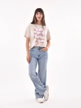 Remera color amarillo claro con estampado de limones, hojas y flores en tonos verdes y grises.