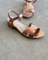 Sandalias bajas negras con tiras finas cruzadas y tobillera con hebilla.