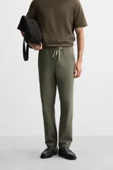 Pantalón de jogging color beige confeccionado en tejido de mezcla de algodón. Cuenta con cintura elástica ajustable con cordón, bolsillos frontales y traseros.