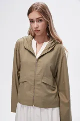 Campera corta color verde oliva, con capucha, cierre frontal con cremallera, bolsillos laterales con solapa y mangas largas.