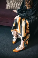 Zapato blucher de cuero con estampado animal print en tonos naranja y plateado, con cordones y detalle de borlas.