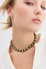 Gargantilla corta con lentejuelas metálicas y plásticas en colores rojo, negro y dorado.