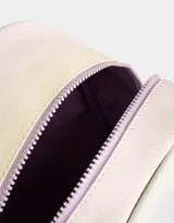 Mochila lila de cuerina con efecto acolchado y colgante de mariposa. Tiene correas regulables, manija superior, acceso con cierre superior y bolsillo frontal con cierre y tirador de goma en forma de mariposa.