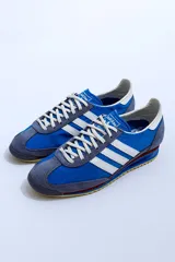 Championes Adidas SL 72 con estampado animal print, cordones naranjas y las tres tiras clásicas en blanco.