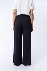 Pantalón deportivo ancho negro con cintura elastizada y cordón ajustable.