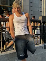 Short de jean negro con efecto lavado, corte a la rodilla y estampado con el logo de la marca en blanco en la pierna izquierda.