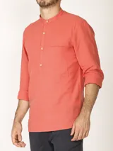 Camisa de lino color salmón con cuello mao, manga larga y bolsillo de parche en el pecho.