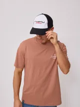 Gorra con visera Rusty, con frente blanco y logo bordado en negro y rojo, malla trasera negra y visera negra.
